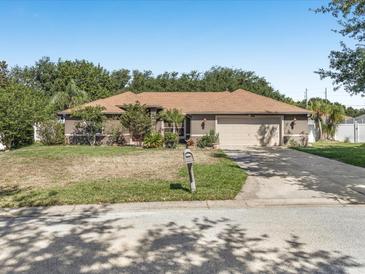 Charming single-story home featuring a well-manicured lawn, a two-car garage, and mature trees in a suburban neighborhood at 10247 Mason Loop, Clermont, FL 34711