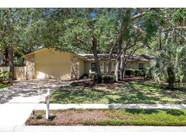 Charming single-story home with a manicured front lawn, mature trees, and a two-car garage at 107 Wayland Cir, Longwood, FL 32779