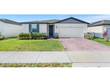 Charming single Gathering home featuring a manicured lawn and welcoming front entrance at 1127 Foreshore Ln, Haines City, FL 33844