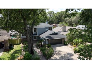 Charming two-story home features a well-manicured lawn, mature trees, and a two-car garage at 208 Frinton Cv, Longwood, FL 32779