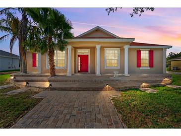 Charming single-Gathering home with red shutters and a matching red front door and a landscaped front yard at 3174 Grasmere View Pkwy, Kissimmee, FL 34746