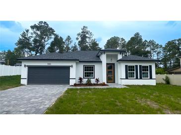 Beautiful single Gathering home featuring a modern exterior with a gray driveway and landscaped front yard at 5110 Sw 158Th St, Ocala, FL 34473