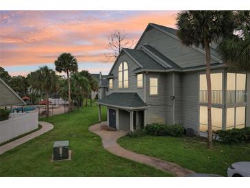 Charming townhouse exterior with lush landscaping, pool access, and serene sunset view at 6088 Westgate Dr # 201, Orlando, FL 32835