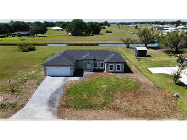 New construction single-Gathering home featuring a brick paved driveway and expansive grassy lawn at 8600 Castile Rd, Sebring, FL 33876