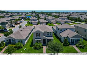 Charming two-story home featuring a well-maintained lawn, complemented by mature trees and manicured landscaping at 9971 Beach Port Dr, Winter Garden, FL 34787