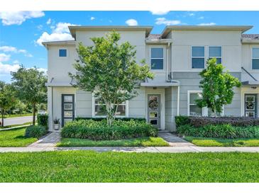 Charming townhome with well-maintained landscaping, complemented by lush green grass and a welcoming facade at 15975 Marina Bay Dr, Winter Garden, FL 34787