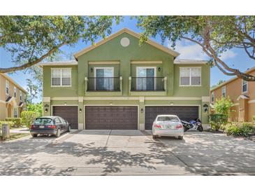 Three-story townhouse with balconies over garages and mature landscaping around the property at 2430 Little Gem Loop, Sanford, FL 32773