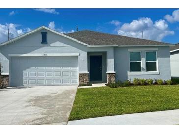Charming single-story home with a two-car garage, well-manicured lawn and neutral paint at 33836 Sky Blossom Cir, Leesburg, FL 34788
