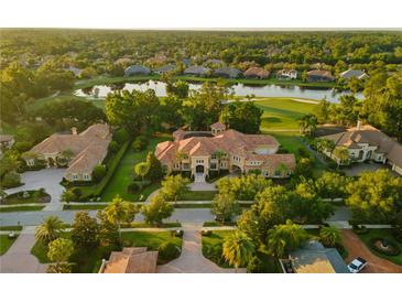 Expansive estate with meticulously landscaped grounds, tile roof, and a serene lake view at 3512 Legacy Hills Ct, Longwood, FL 32779