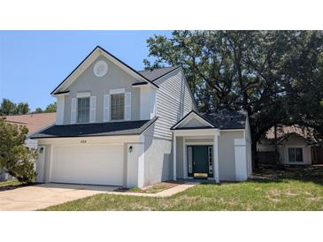 Charming two-story home featuring a two-car garage, gray stucco and dark green door at 609 Whittingham Pl, Lake Mary, FL 32746