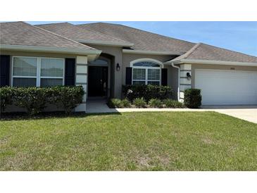 Charming single-story home with a well-manicured lawn and inviting curb appeal, complemented by lush landscaping at 6800 Se 12Th Pl, Ocala, FL 34472