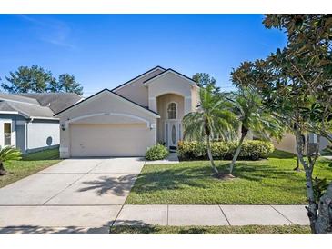 Charming two-story home featuring a well-maintained lawn and a two-car garage at 12756 Maribou Cir, Orlando, FL 32828