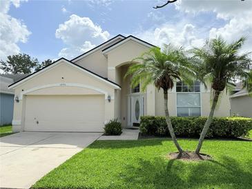 Charming single-Gathering home with a two-car garage, well-manicured lawn, and tropical palm trees at 12756 Maribou Cir, Orlando, FL 32828