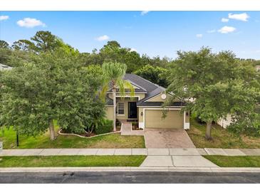 Charming single-story home featuring a brick driveway, lush landscaping, and a two-car garage at 1601 Stargazer Ter, Sanford, FL 32771