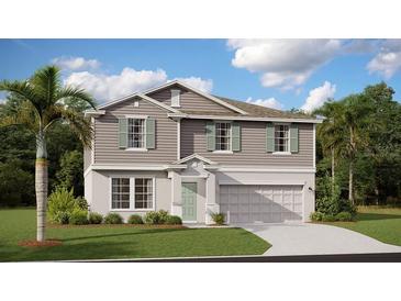 Two-story home with gray siding, light green shutters, a manicured lawn, and a two-car garage at 7542 Headwaters Ct, Groveland, FL 34736