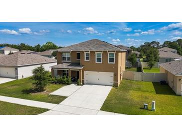 Charming two-story home with a well-manicured lawn and a two car garage at 2752 Grand Central Ave, Tavares, FL 32778