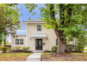 Charming two-story home with black front door, manicured landscaping and mature trees at 490 Shoreview Ave, Winter Park, FL 32789