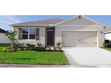 Charming single-story home featuring a two-car garage, well-manicured lawn, and neatly landscaped front yard at 5145 Masser Rd, St Cloud, FL 34772