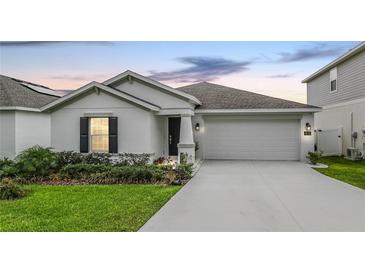Charming single-story home featuring a well-maintained lawn and attached two-car garage at 818 Kapi Dr, Groveland, FL 34736