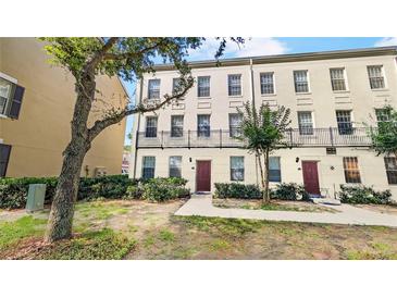 Three story townhouse with a landscaped front yard with a walkway to the front door at 1038 Waterside Dr, Celebration, FL 34747