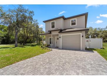 Charming two-story home with a well-maintained front yard and a brick-paved driveway leading to the garage at 146 E 15Th St, Apopka, FL 32703