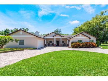 Stunning exterior with manicured lawn, brick driveway, and beautiful landscaping at 2106 Tuscarora Trl, Maitland, FL 32751
