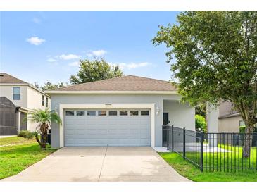 Charming single-story home with a gray exterior, attached garage, and well-maintained lawn at 2125 Shackley Pl, Apopka, FL 32703