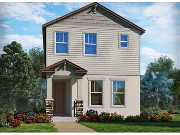 Charming two-story home featuring neutral siding, stone accents, a covered entry, and professionally landscaped front yard at 4537 Cross Prairie Pkwy, St Cloud, FL 34772