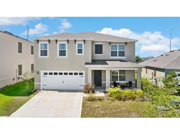 Charming two-story home with a two-car garage, covered porch and manicured landscaping at 616 Griffon Ave, Lake Alfred, FL 33850