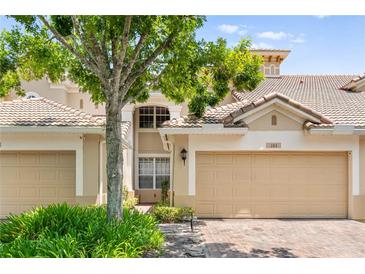 Charming villa with a two-car garage, well-maintained landscaping, and a classic Spanish tile roof at 6205 Miramonte Dr # 103, Orlando, FL 32835