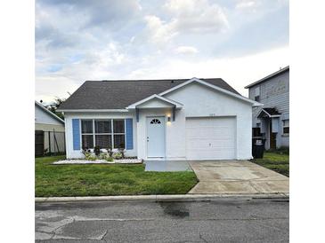 Charming single-story home featuring white stucco exterior, blue shutters, and a well-maintained lawn at 1025 Clovercrest Rd, Orlando, FL 32811