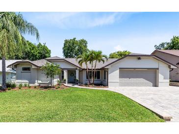 Charming single-story home with a well-manicured lawn, lovely landscaping, and a two-car garage at 1172 Trotwood Blvd, Winter Springs, FL 32708