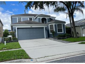 Charming two-story home featuring a two-car garage, gray facade, and manicured landscaping at 14936 Masthead Landing Cir, Winter Garden, FL 34787