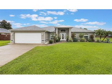 Charming single-story home with a well-manicured lawn and neutral exterior at 2113 Kirkland Lake Dr, Auburndale, FL 33823