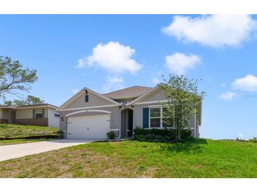 Charming single-story home with a manicured lawn, attached garage, and neutral-tone siding under a sunny sky at 2135 E Old Mill Dr, Deltona, FL 32725