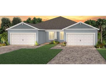 Beautiful, light blue single-story home with a well-maintained lawn, a two-car garage and a brick driveway at 2322 Daisy Tree Rd, St Cloud, FL 34771