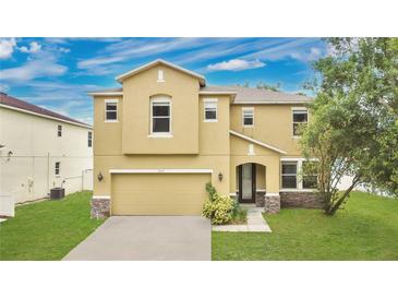Two-story home featuring an attached two-car garage and well-maintained lawn at 7469 Hunters Greene Cir, Lakeland, FL 33810