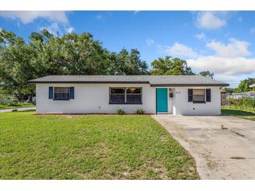 Charming one-story home with a well-maintained lawn and a bright teal front door at 911 Ursula St, Ocoee, FL 34761