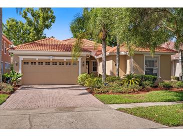 Charming single-story home featuring a tile roof, brick driveway, and lush landscaping at 11316 Rapallo Ln, Windermere, FL 34786