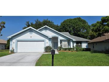 Charming single-story home features a well-manicured lawn and attached two-car garage at 11818 Sophia Ln, Orlando, FL 32821