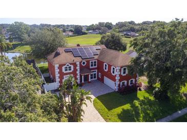 Stunning two-story home with a red exterior, white trim, and a solar panel roof system at 1254 Shelter Rock Rd, Orlando, FL 32835