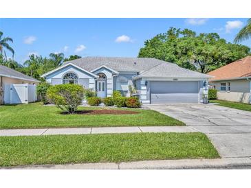 Charming single-Gathering home with a well-maintained lawn, gray paint, and a two-car garage at 12618 Lakebrook Dr, Orlando, FL 32828