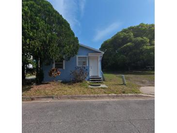 Charming single-story home with a blue exterior, white door, and mature tree in the front yard at 2031 Warrens Ave, Maitland, FL 32751