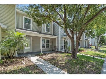 Charming two-story home with a sidewalk leading to the front door and a mature tree providing shade at 283 Woodgreen Ln, Winter Springs, FL 32708