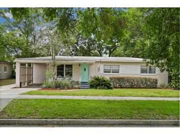 Charming single-story home featuring a light pink exterior, quaint front yard and a light teal colored front door at 3007 Huntington St, Orlando, FL 32803