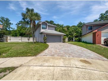 Charming home with a well-manicured lawn, brick driveway, and tropical landscaping at 306 Foxboro Ct, Lake Mary, FL 32746