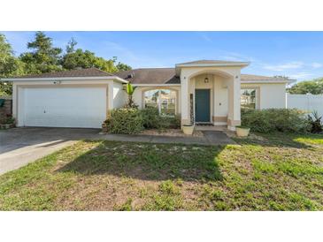 Charming single-story home with a two-car garage, manicured landscaping, and welcoming front porch at 3270 Courtland Blvd, Deltona, FL 32738