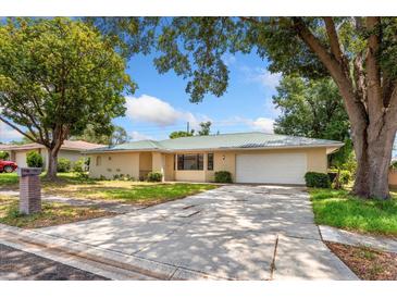 Charming single-story home with a metal roof, mature trees, and a two-car garage at 611 Lakespur Ln, Altamonte Springs, FL 32714