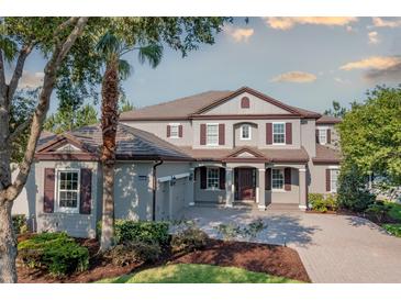 Elegant two-story home with a well-manicured lawn and charming curb appeal with its symmetrical windows and neutral paint scheme at 7536 Green Mountain Way, Winter Garden, FL 34787