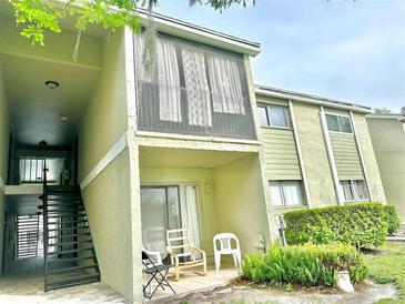 Two-story condo featuring an outdoor patio with chairs and second story screened in porch at 912 Lake Destiny Rd # F, Altamonte Springs, FL 32714